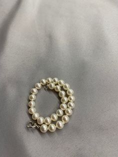 White Freshwater Pearl Bracelet. This bracelet features 28 White Freshwater Pearls AAA round to near round high luster 6.2mm with a heart clasp that is 18K white gold plate over 925 silver. The bracelet is 7 1/2 inches long measured laying flat. I hand knotted this bracelet using spectra thread. I use it instead of silk for my freshwater pearls. It does not stretch, hold oils, or break easily. It can also be gotten wet. I also like the heart clasp, they are easier to connect. We guarantee all of Elegant Pearl Bracelet With Lobster Clasp And Round Beads, White Single Strand Round Bracelet, White Round Single Strand Bracelet, White Pearl Bracelet With Lobster Clasp And Round Beads, Silver Single Strand Pearl Bracelet, White Pearl Bracelet With Lobster Clasp, White Single Strand Round Pearl Bracelet, Elegant White Pearl Bracelet With Lobster Clasp, White Single Strand Pearl Bracelet