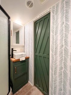 a green door in a bathroom next to a sink