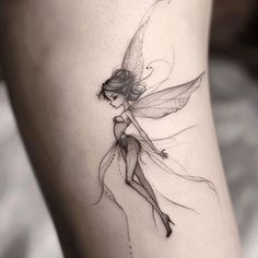 a woman's leg with a fairy tattoo on the side of her thigh,