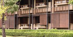 an apartment building with wooden balconies and brown blinds on the windows is shown