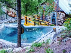 an outdoor hot tub surrounded by trees and rocks