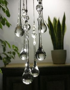 a chandelier with spoons hanging from it's sides in front of a potted plant