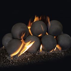 a pile of rocks sitting next to each other on top of a fire pit with flames coming out of them