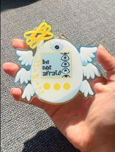 someone holding up a badge with an angel on it that says be not afraid to fly