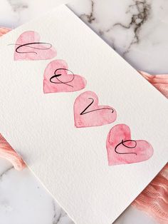 a card with the word love written on it and two hearts drawn in black ink