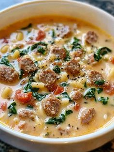 a white bowl filled with soup and meatballs