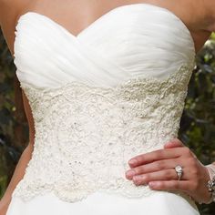 a woman in a wedding dress holding her hand on her waist