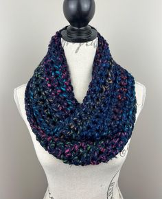 a multicolored knitted scarf on top of a mannequin headdress