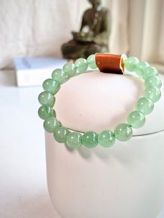 "An 8mm Green Aventurine crystal bracelet of top quality semi precious gemstones, with optional silk, .925 sterling silver or 24k gold vermeil charm. Aventurine is a form of quartz, characterized by its translucency and the presence of platy mineral inclusions that give it a shimmering or glistening effect termed aventurescence. You will receive one (1) bracelet with optional charm. All jewelry orders over $25 receive a premium AHANA CRYSTALS jewelry pouch.  AHANA CRYSTALS are hand chosen, top grade pieces. Beautiful, natural variations may vary in color, inclusions, size, shape, weight, and more.   Bracelet charm options include: A) Silk Tassel B) .925 Sterling Silver Flat Disc C) 24K Gold Vermeil Disc D) .925 Sterling Silver Flat Lotus E) .925 Sterling Silver Flat Leaf F) .925 Sterling S Jade Crystal Bracelet With Gemstone Beads For Healing, Jade Gemstone Beaded Bracelets For Meditation, Elegant Aventurine Beaded Bracelets For Healing, Everyday Jade Bracelets With Round Beads, Everyday Jade Beaded Bracelets With Round Beads, Healing Jade Beaded Crystal Bracelet, Aventurine 8mm Beads Bracelet For Meditation, Adjustable Aventurine Gemstone Beaded Bracelets, Meditation Aventurine 8mm Beads Bracelet