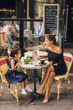 a woman sitting at a table with two small children