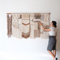 a woman standing in front of a wall hanging