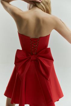 Introducing the Emily Dress with Bow: a stunning mini satin dress in a vibrant red color, designed to make a bold statement. This eye-catching dress features a dramatic maxi bow at the lower back, perfect for girls who love to stand out and make an impression. The Emily Dress is not only striking in design but also offers a perfect fit with adjustable lacing at the back. This ensures that you feel comfortable and confident throughout any special event. The vibrant red hue enhances its sophistica Black Elopement Dress, Black Elopement, Mini Satin Dress, Dress With Big Bow, Custom Wardrobe, Red Bow Dress, Bday Dress, Wedding Guest Outfit Ideas, Jade Dress