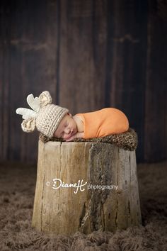 a baby sleeping on top of a wooden stump