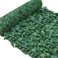 a roll of green grass with leaves on it and a mesh fence over the top