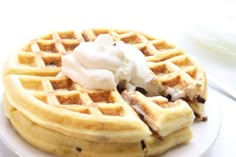 a waffle topped with whipped cream on a white plate