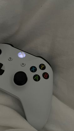 a close up of a controller on a white cloth covered surface with black and red buttons