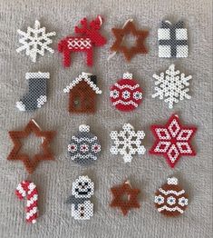 christmas ornaments made out of perler beads on a white towel with red and black snowflakes