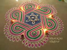 an intricate design on the ground with lights around it and some beads in the middle