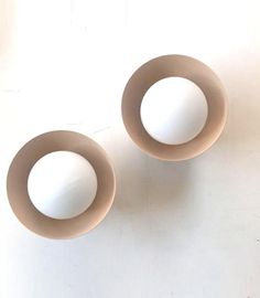 two white bowls sitting next to each other on a table