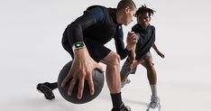 two people are playing with a ball while one person is wearing an apple watch on his wrist