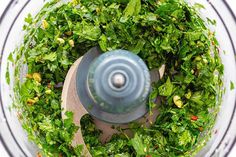 a food processor filled with greens and spices