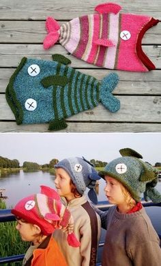 three children wearing knitted hats with fish on them, one is pink and the other is green