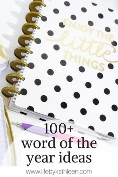 a notebook with the words, 100 + word of the year ideas on it and a pen