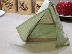 a green and white tent sitting on top of a kitchen counter next to two jars