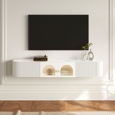 an entertainment center with a flat screen tv mounted on it's sideboard in a living room