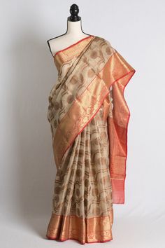 Blended Zari Kota Banarasi Saree in Beige, Red and Antique Gold. Semi, blended and art means it has synthetic fabric mixed. The fall pico is done on the saree and the blouse piece is cut and separated from the saree.   Color - Beige, Red and Antique Gold. Fabric - Blended Zari Kota. Technique - Woven. Blouse Piece - Yes (cut & separated ). Fall / Pico - Yes. Note: There may be minor variations in the shade of the product. Colors/textures show differently based on lighting, gadget settings, etc. Any displacements to stones, sequins, beads or embroidery cannot be deemed as defect in the garment/jewellery but is caused by the very nature of the work. However, missing stones or minute gaps in embroidery does not affect the overall look of the saree. Transitional Cotton Silk Saree For Puja, Transitional Slub Silk Saree With Pallu, Anarkali Cotton Silk Traditional Wear With Zari Weaving, Traditional Cotton Silk Wear With Zari Weaving For Puja, Cotton Silk Traditional Wear With Pallu For Puja, Festive Cotton Silk Saree For Puja, Cotton Silk Saree For Diwali Puja, Cotton Silk Saree For Puja And Diwali, Cotton Silk Saree With Zari Work For Transitional Season