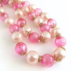 "Hot pink bubble beads and pale pink faux pearls in a double strand choker--perfect for your favorite cocktail dress or caftan! the beads are interspersed with rhinestone ring beads and goldtone filigree fittings. Super fun! 14-1/2\" long with a 3\" adjustable tail. Have even more fun with 2 pink chokers together! (Last photo shows them both) Check out my other listing: https://www.etsy.com/listing/1105538441/pink-pearl-jeweled-choker" Pink Beaded Necklaces For Party, Pink Round Beaded Necklaces For Party, Feminine Pink Pearl Necklace, Pink Pearl Chain Jewelry With Round Beads, Pink Pearl Beaded Necklaces For Parties, Pink Pearl Chain Beaded Necklaces With Round Beads, Pink Pearl Chain Beaded Necklace With Round Beads, Pink Pearl Chain Necklace With Round Beads, Pink Pearl Chain Beaded Necklaces For Wedding