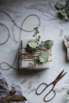 the wrapping paper is wrapped in twine and tied with twine, surrounded by other crafting supplies