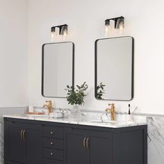 two mirrors are above the double sink vanity in this white and black bathroom with marble countertops