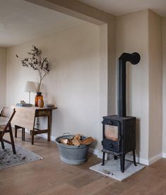 a living room with a wood stove in the corner and a table next to it