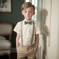 a young boy wearing suspenders and a bow tie