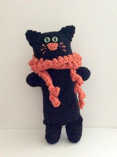 a black cat stuffed animal wearing a scarf