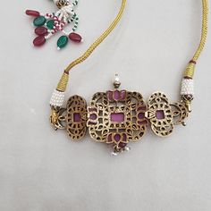 This Victorian choker is designed with rubies and polki. The rubies are framed in four lotus design, each set within an elaborate design of uncut polki stones. The elegant combination of ruby and polki is set in a vintage-inspired design, offering a timeless and royal look. Perfect for those who appreciate traditional craftsmanship with a touch of Victorian charm. It can be used as an armlet Bajuban. Material : 92.5 Hallmarked silver Stones : Moissanite polki, semi precious ruby, pearls Victorian Ruby Jewelry With Intricate Design, Victorian Ruby Jewelry For Collectors, Victorian Ruby Earrings, Luxury Victorian Ruby Jewelry, Polki Victorian Choker, Royal Look, Lotus Design, Elephant Pendant, Pin Pendant