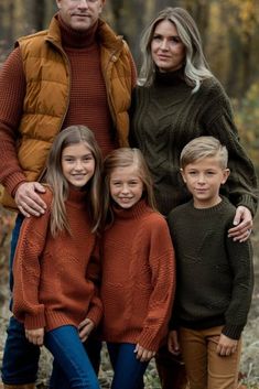 a family posing for a photo in the woods