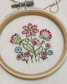 a close up of a embroidery on a wooden hoop