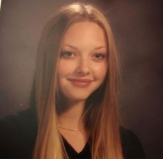 a woman with long blonde hair is smiling at the camera