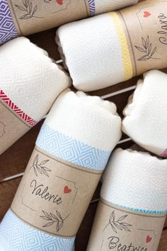 several rolls of toilet paper sitting next to each other on a wooden table with labels