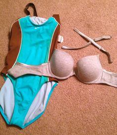 a woman's swimsuit and accessories laid out on the floor