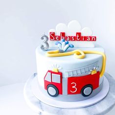 a birthday cake with a firetruck and number 3 on it's side