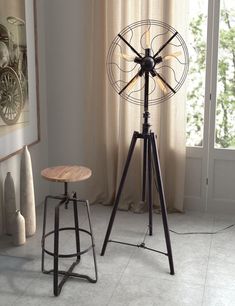 an industrial style floor lamp next to a stool and table in front of a window