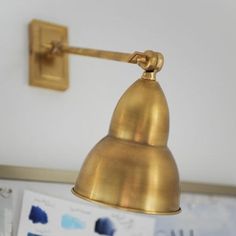 a gold colored light hanging from a wall