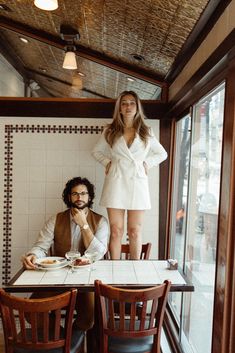 a man and woman sitting at a table in a restaurant