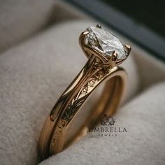 a close up of a ring with a diamond in it on a white cloth surface