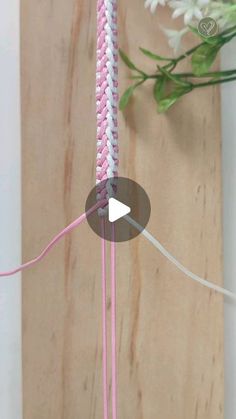 a video demonstrating how to make a crochet necklace with pink and white yarn