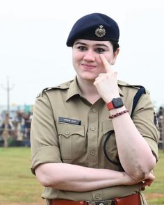 a woman in uniform is posing for the camera with her hand on her chin and looking at the camera