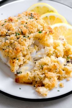 a white plate topped with fish and lemon slices